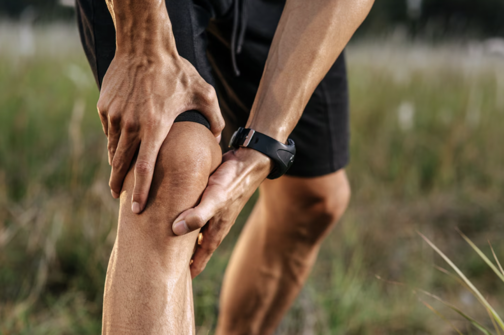 Person experiencing muscle and joint discomfort after physical activity.