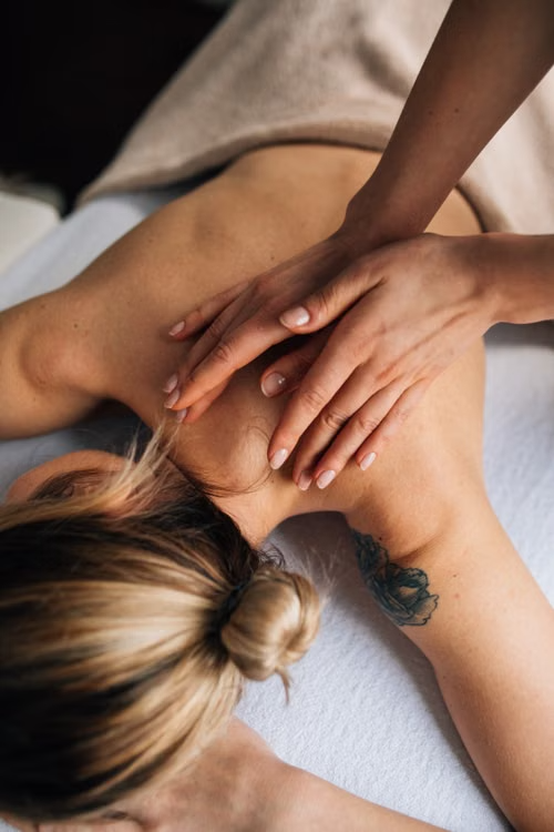A woman getting her neck massaged on the table. 
